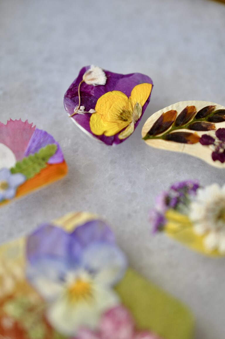 Close-up view of a handmade dog paw print made from real pressed flowers in vibrant colors.