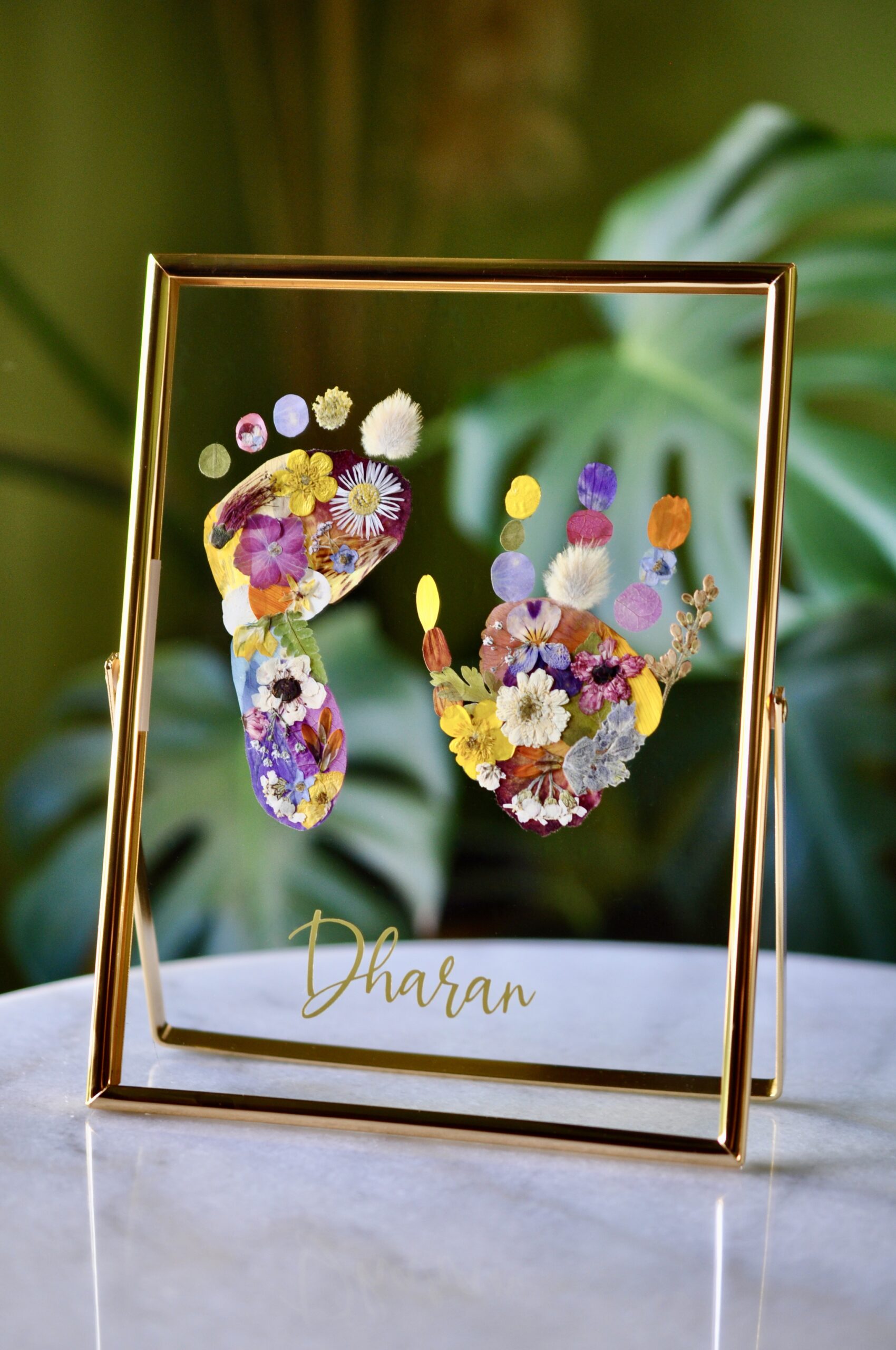 Personalised baby hand and footprint made from real pressed flowers with the name Dharan.