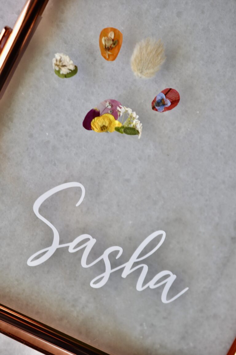 Custom dog paw print made from real pressed flowers with the pet’s name labeled on the glass.