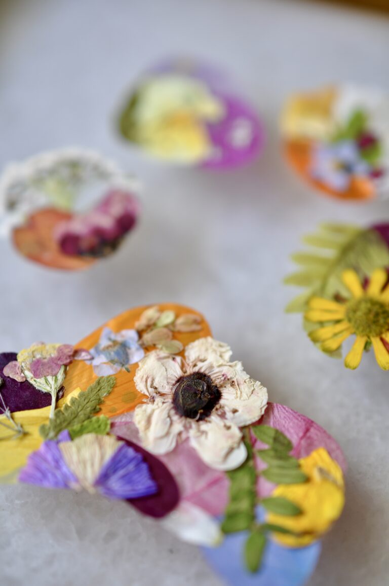Close-up view of a handmade dog paw print made from real pressed flowers in vibrant colors.