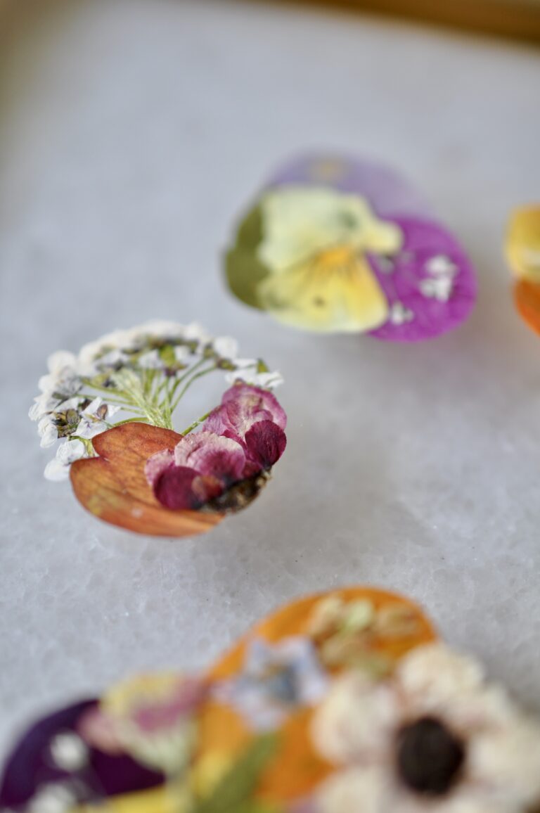 Close-up view of a handmade dog paw print made from real pressed flowers in vibrant colors.