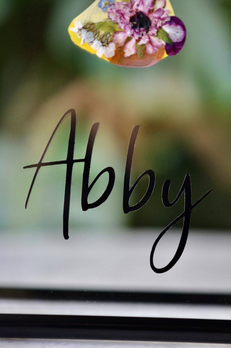 Custom dog paw print made from real pressed flowers with the pet’s name labeled on the glass.