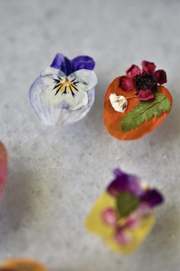 Close-up view of a handmade dog paw print made from real pressed flowers in vibrant colors.