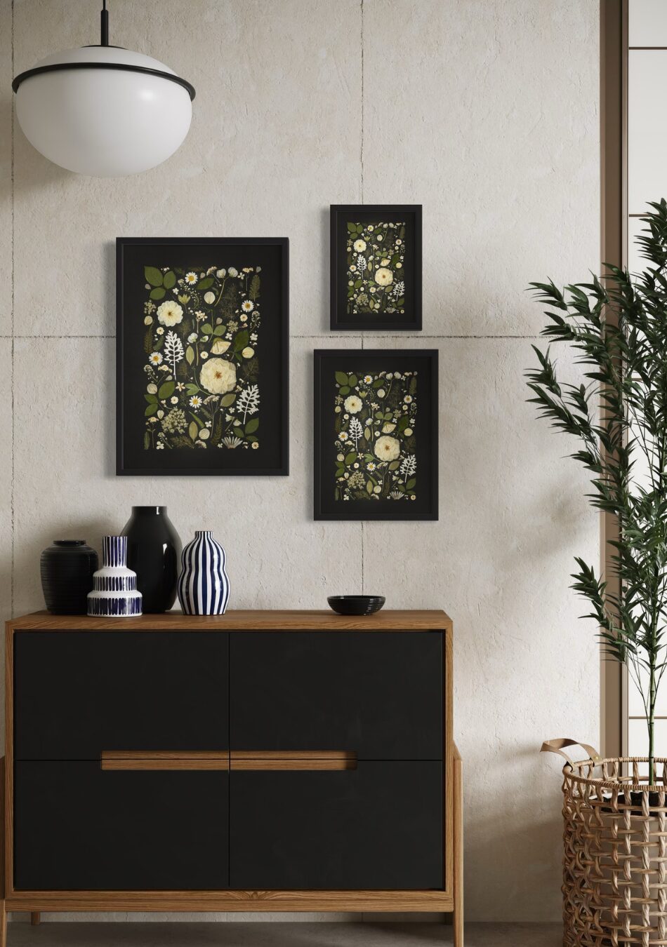 Three framed Midnight Meadow pressed flower prints in A2, A3, and A4, featuring white florals and greenery on a black background, styled on a light wall above a modern wooden sideboard