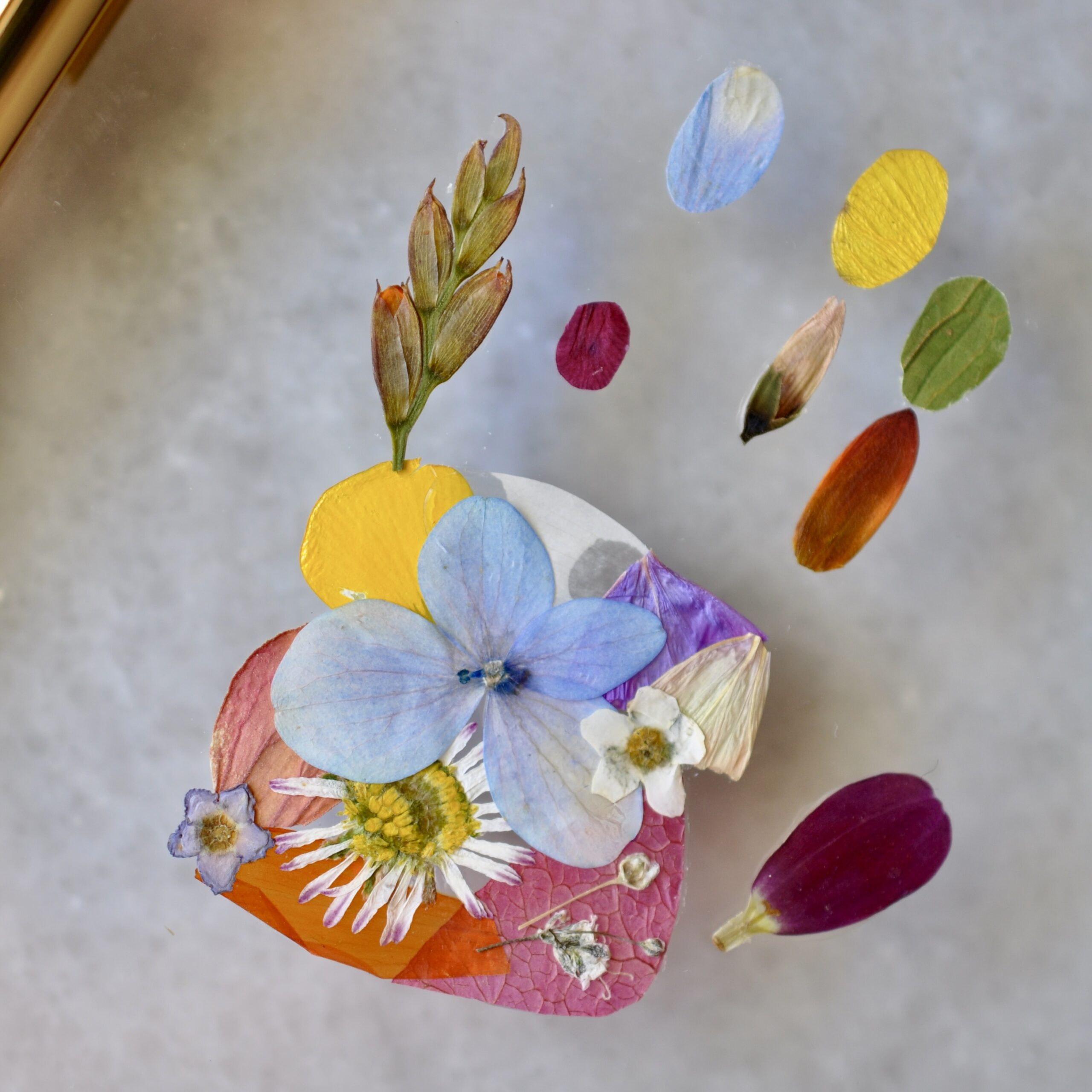 Gold double glass frame displaying a baby’s tiny hand and footprint made from real pressed flowers, with the name “Roen” in gold lettering
