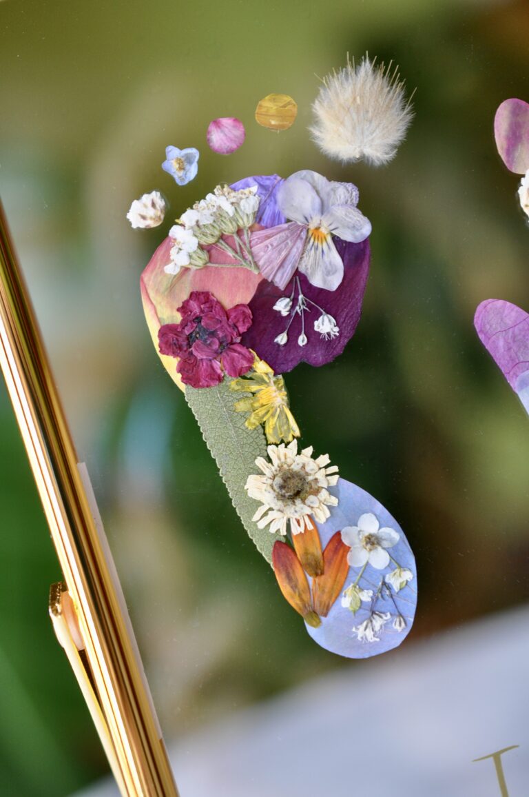 Close-up of floral baby footprint keepsake in a gold frame – personalised newborn gift made with real pressed flowers