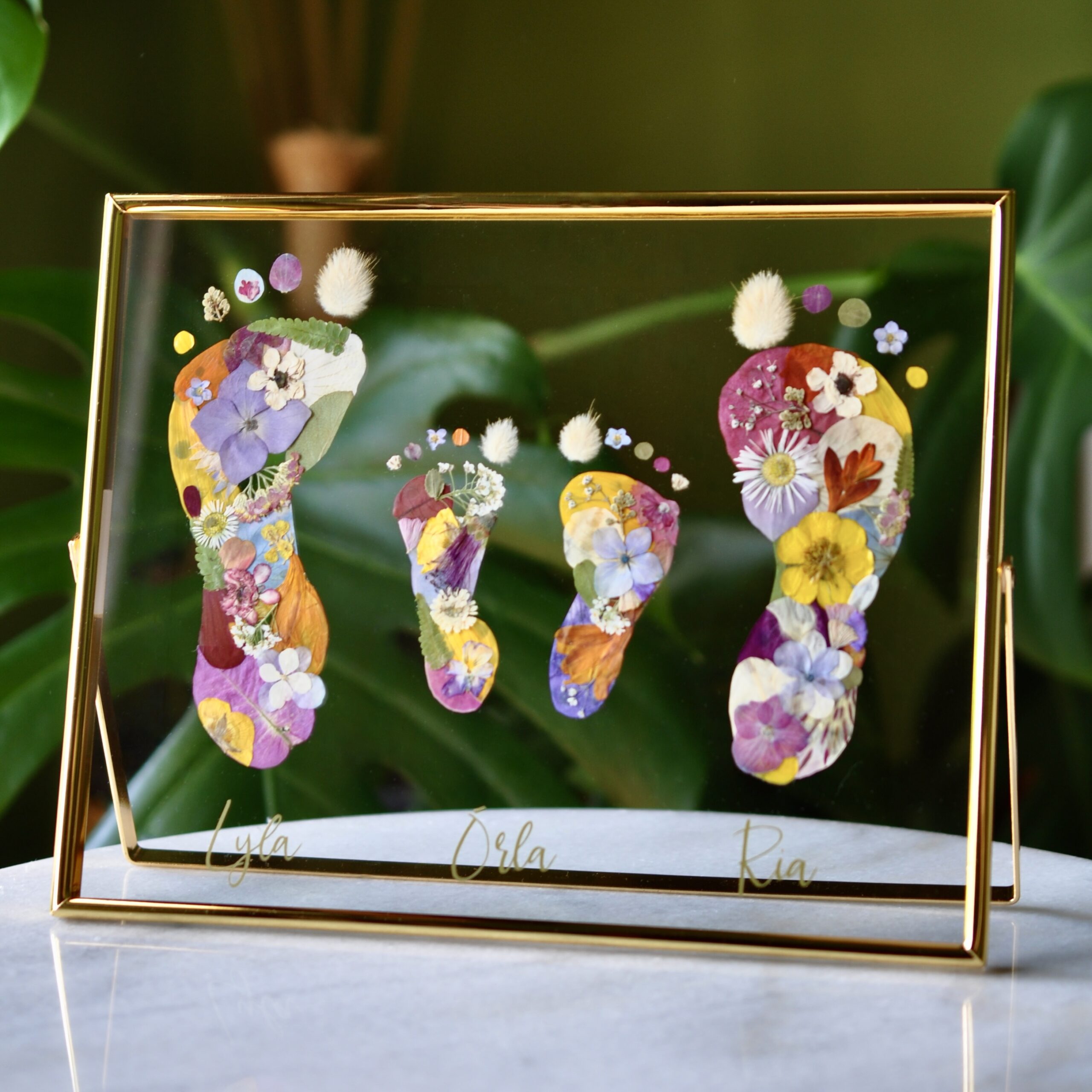 Sibling Keepsake with feet out of pressed flowers in golden frame