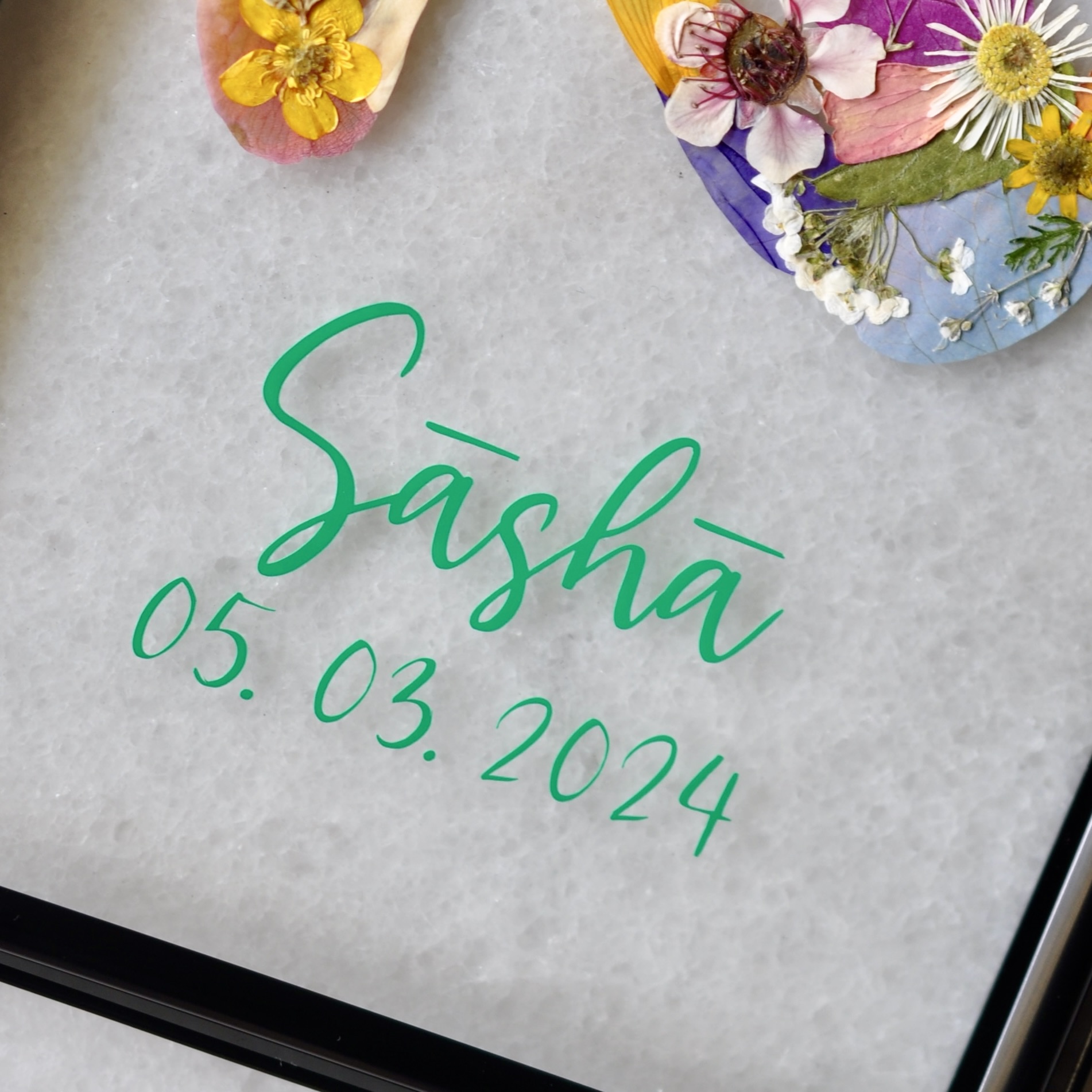 Baby Keepsake out of pressed flowers with green labelling