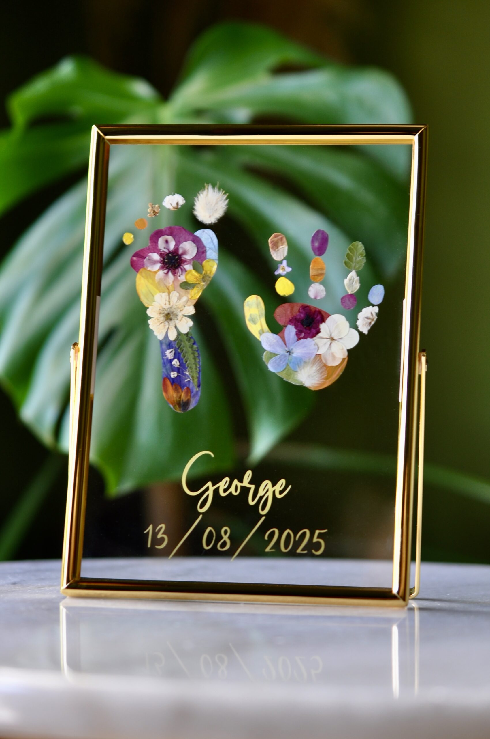 Pressed flower baby hand and footprint keepsake, handmade floral artwork preserving newborn memories, created in Nelson, New Zealand.