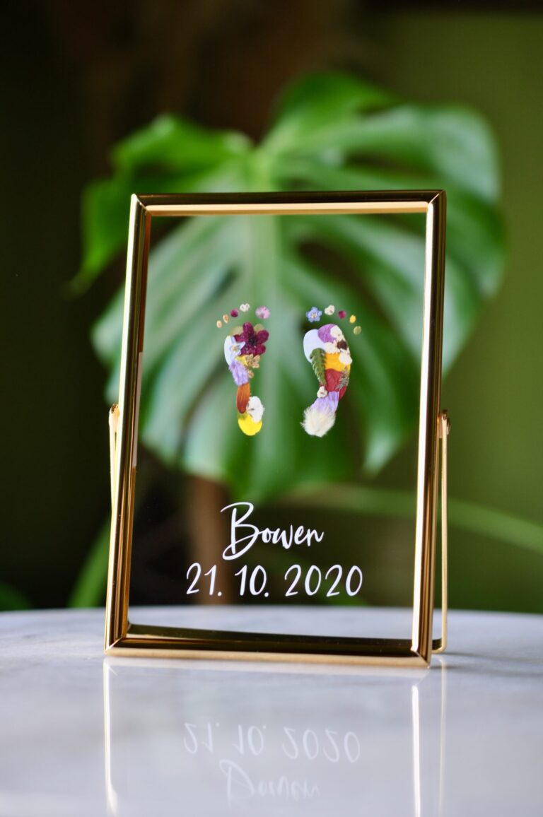 two baby feet out of pressed flowers with name and date