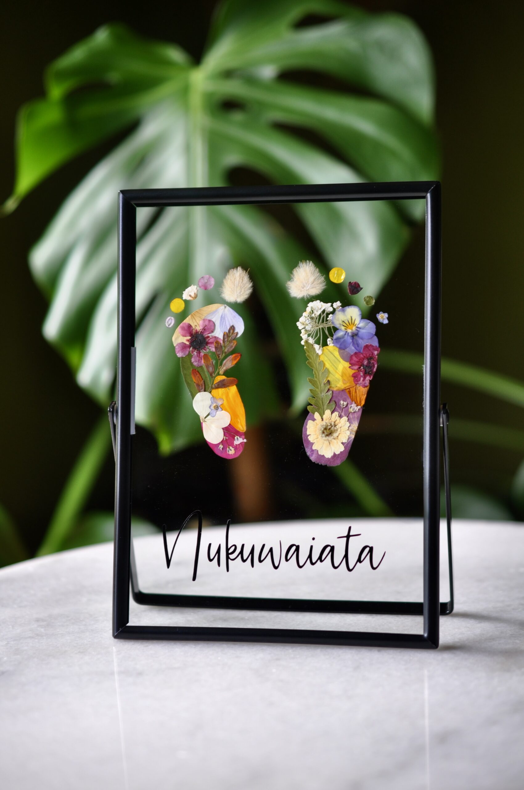 baby footprint keepsake made from pressed flowers, a unique handmade artwork celebrating newborn memories.