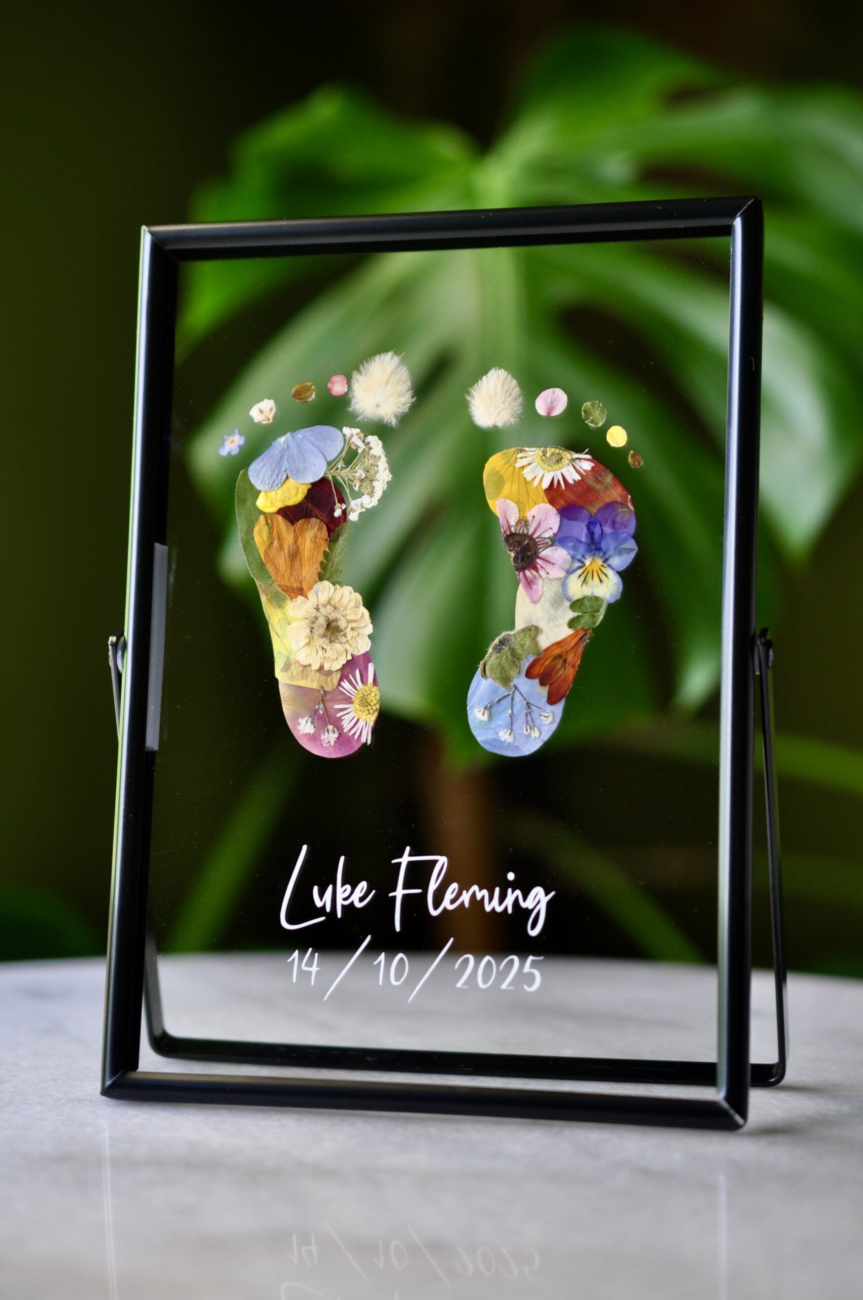 baby footprint keepsake made from pressed flowers, a unique handmade artwork celebrating newborn memories.