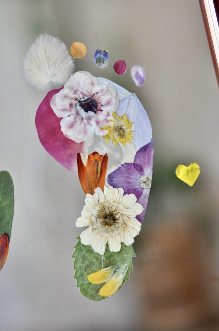 Close up of baby foot out of pressed flowers with a little heart