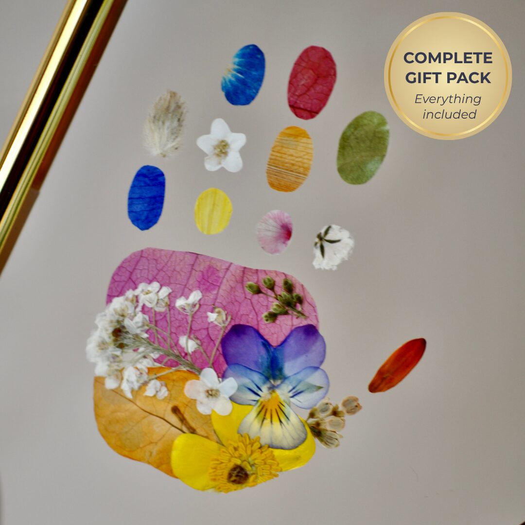 Handmade floral footprint keepsake for babies featuring colourful pressed flowers, gold frame, satin ribbon and custom baby name and birth date.