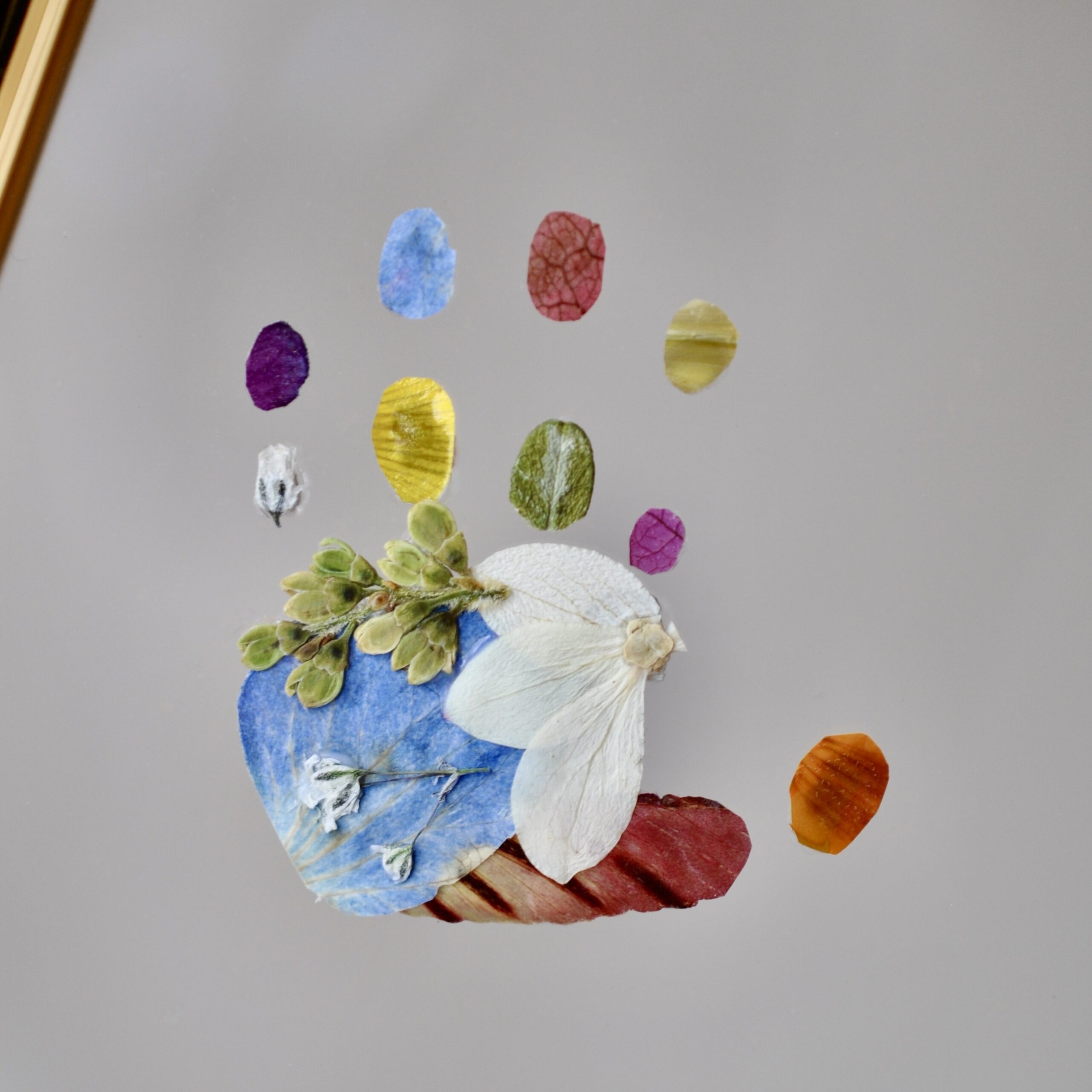 baby handprint made out of colourful pressed flowers