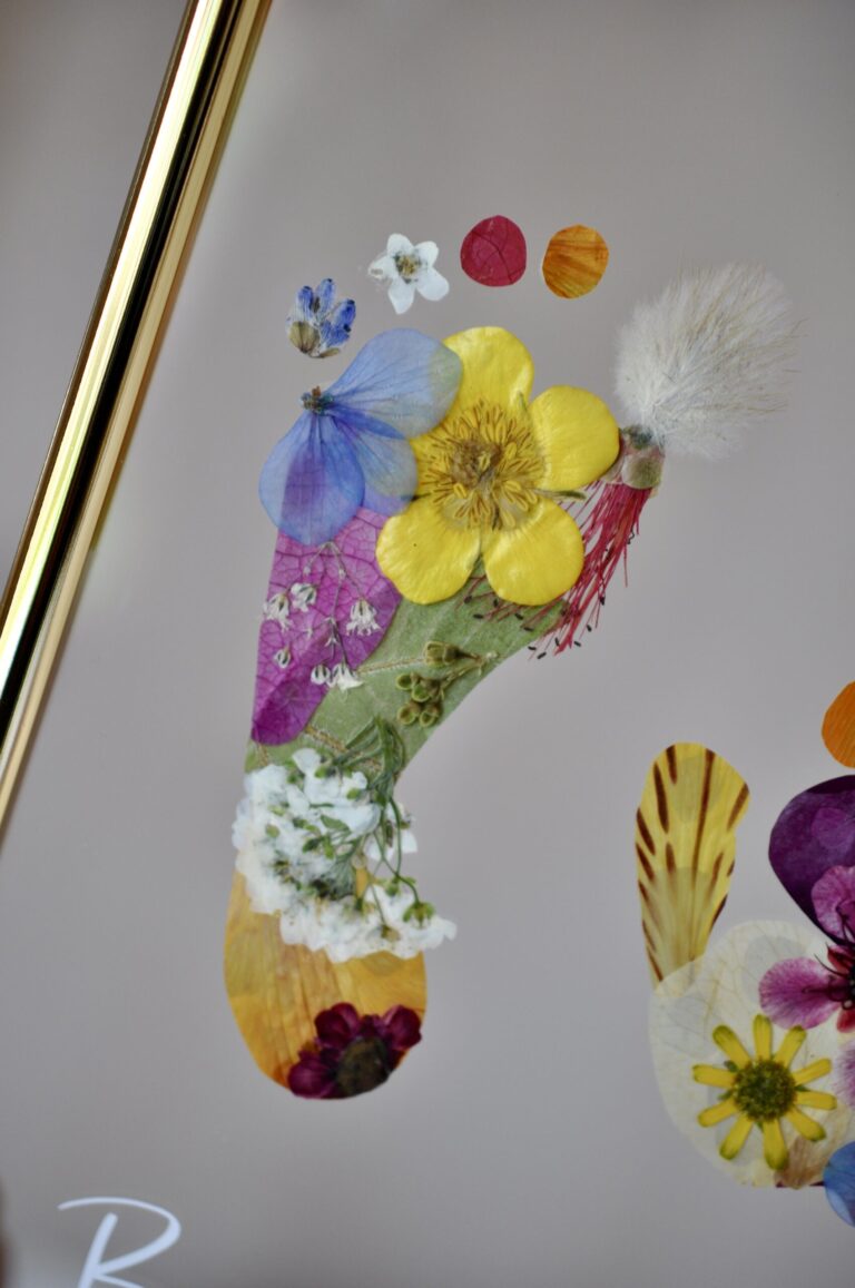 Close up baby footprint made out of pressed flowers